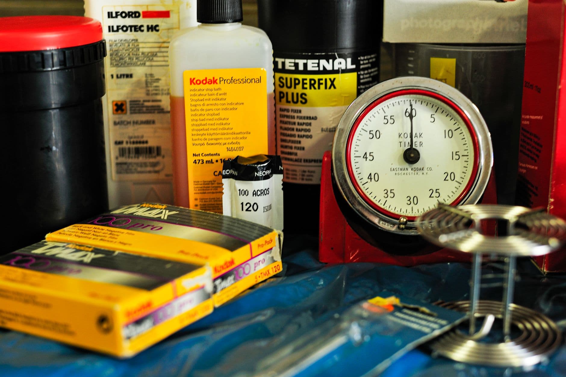 Analog film rolls and developer bottles on a work surface.