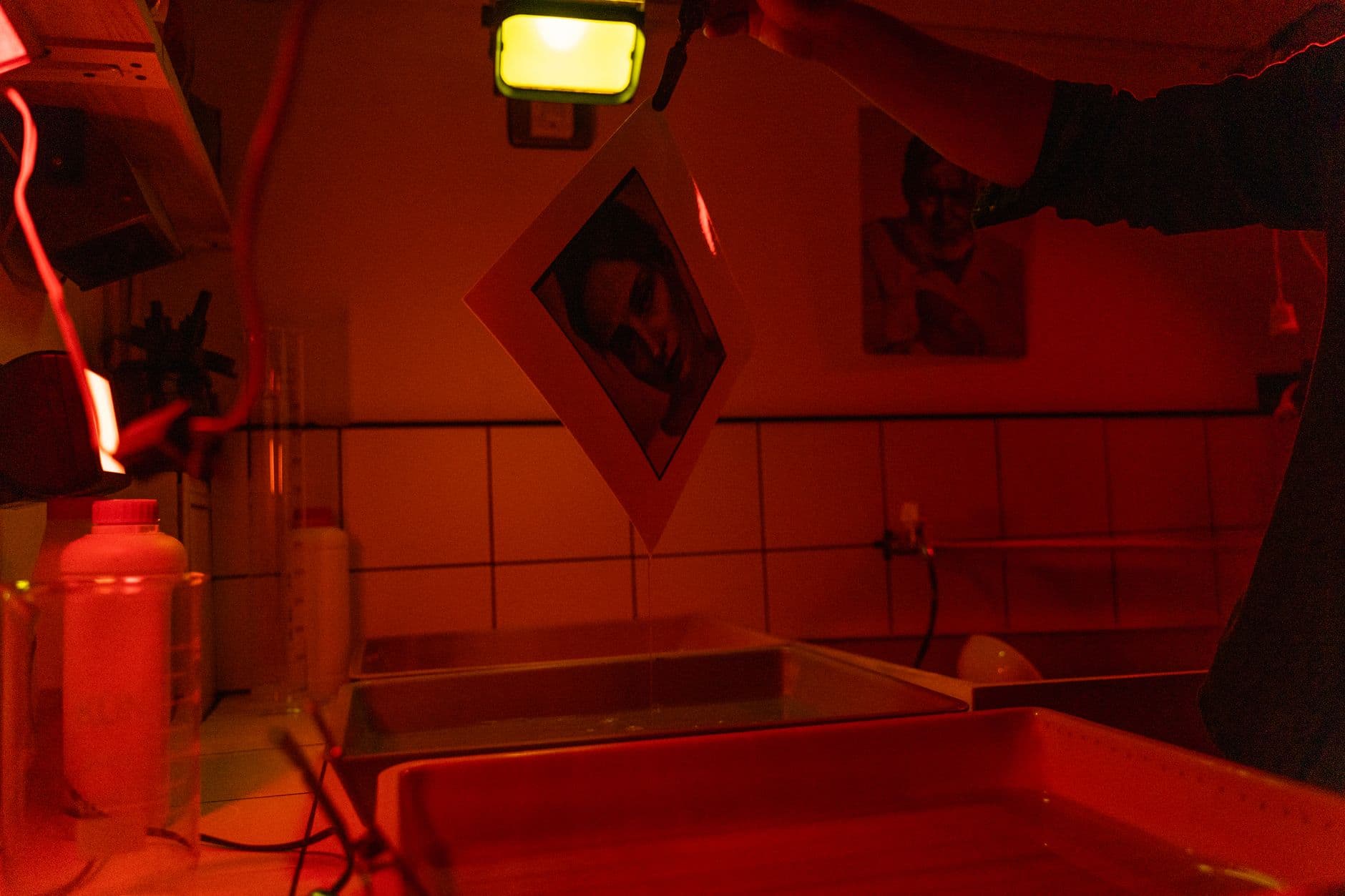 Photographer working with chemistry at a darkroom bench.
