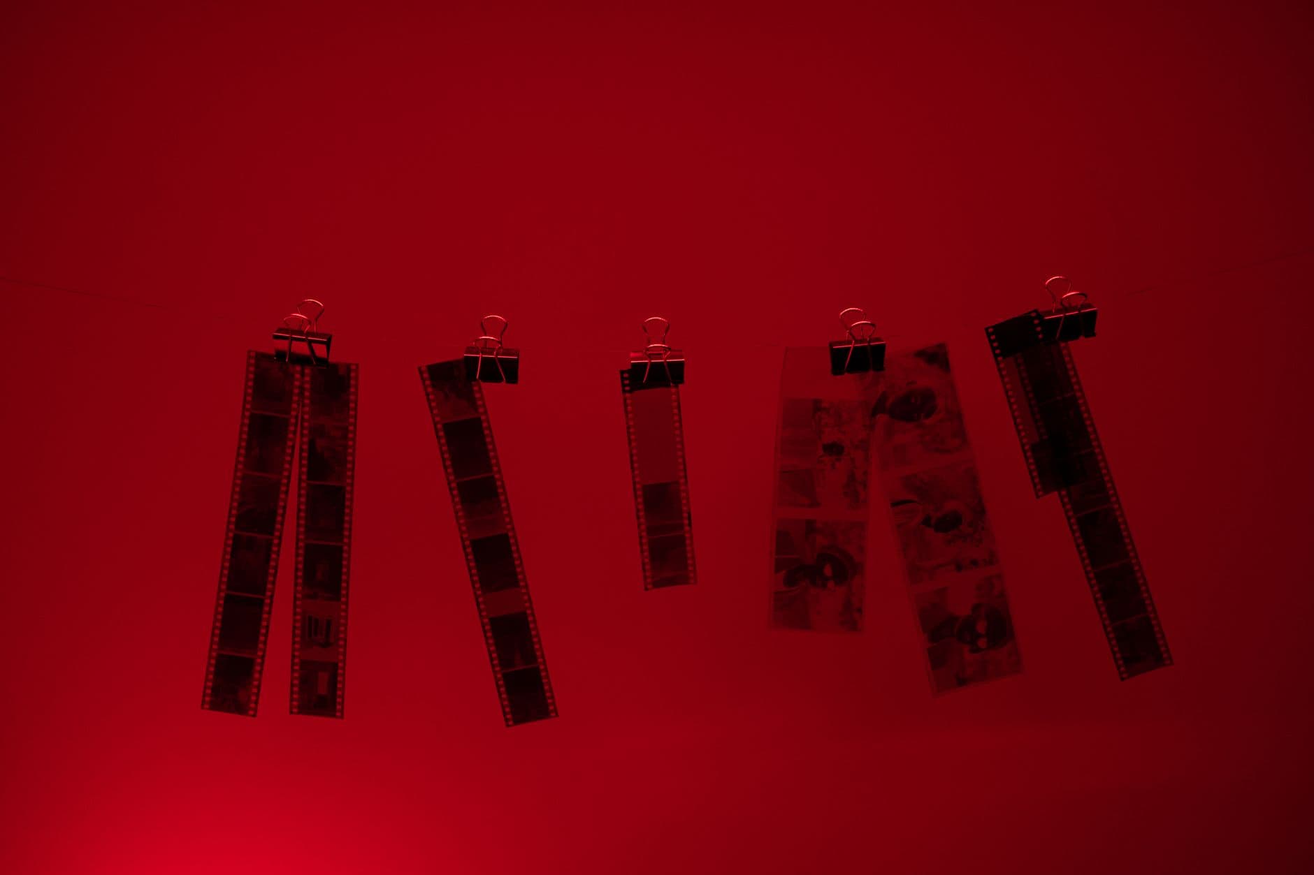 Film strips hanging to dry in a darkroom.