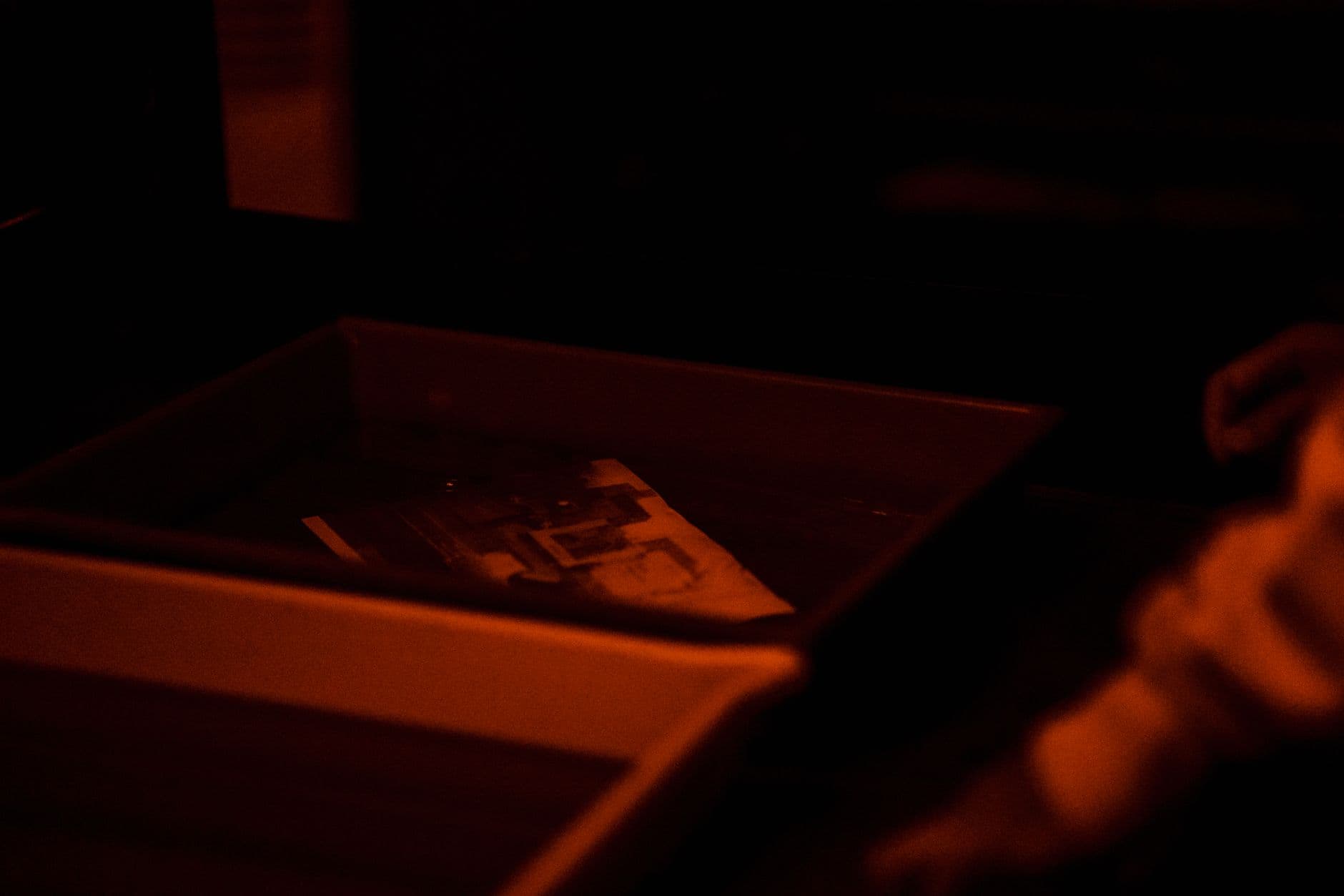 Close-up of a print developing in a darkroom tray.